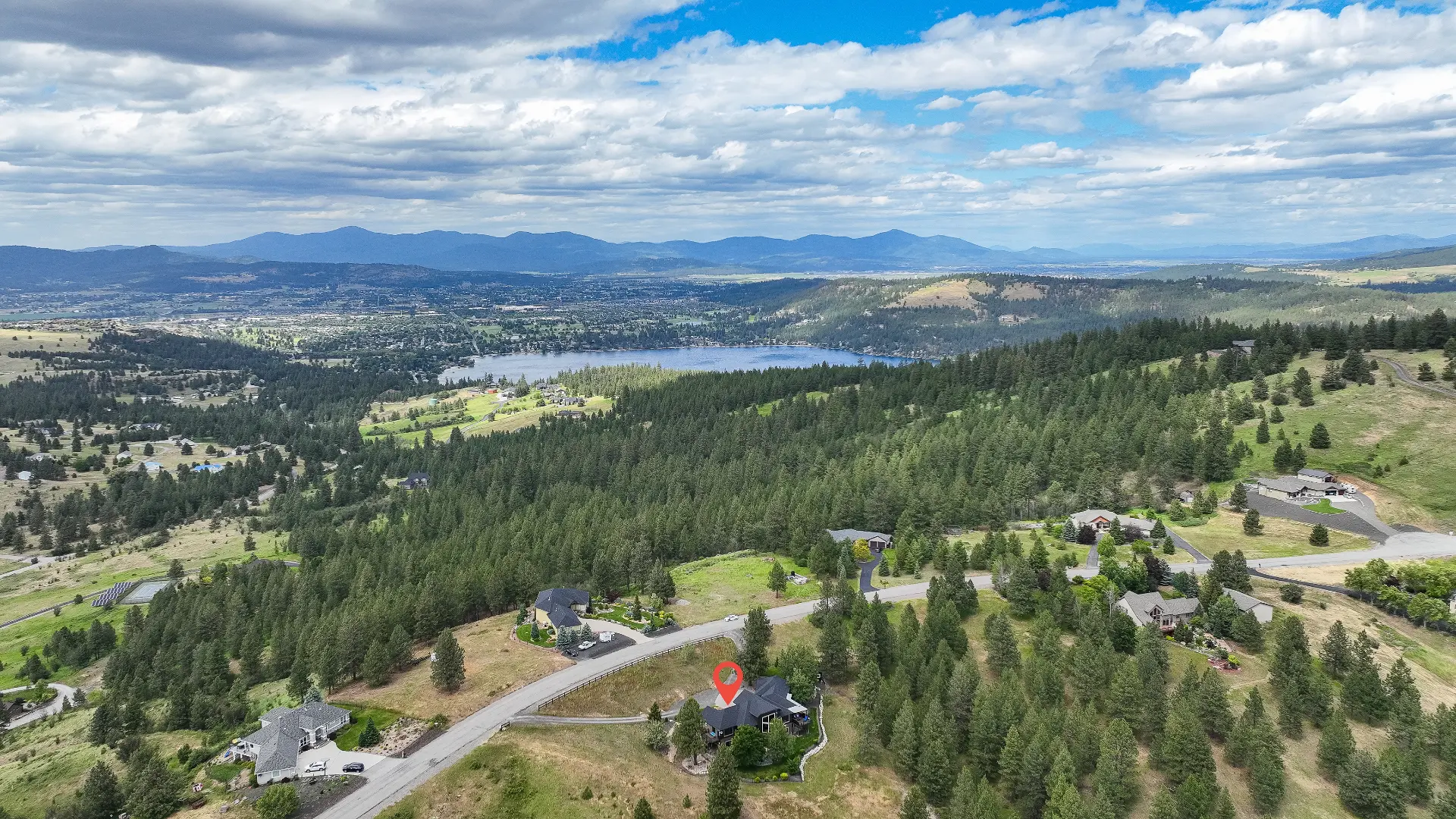 Aerial drone photograph of a Spokane-area property with lake and mountain views